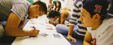 Latin American young people working on a banner