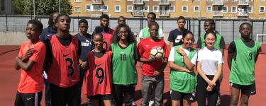 Two football teams of young adults wearing vests